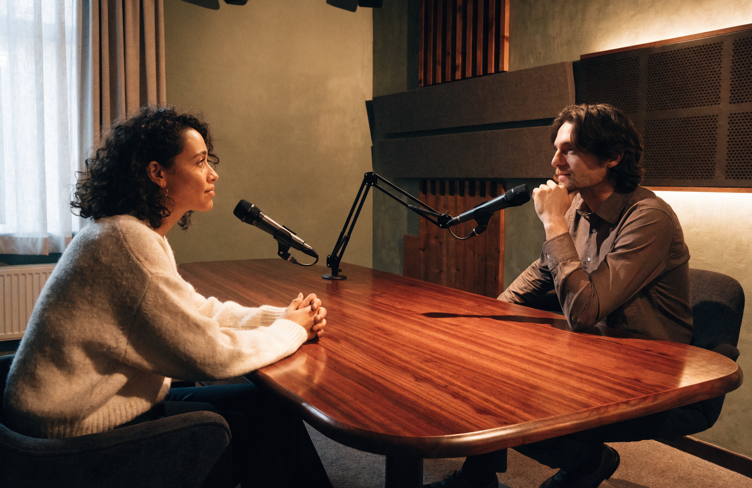 Illustration IA : échange entre deux personnes autour de microphones.